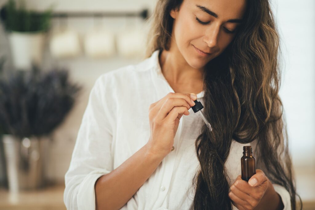 woman applying natural organic essential oil on ha 2022 11 15 06 24 18 utc