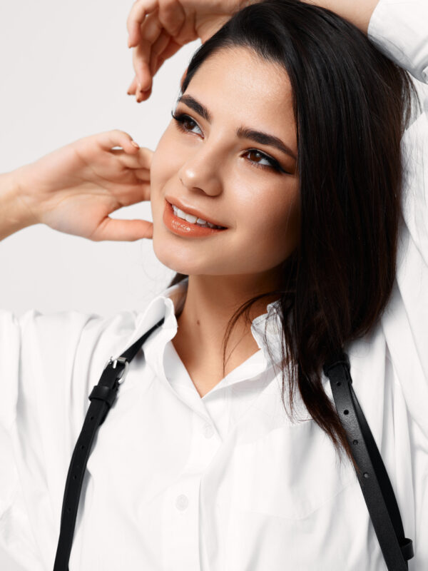 woman white shirt with black suspenders gestures with her hands